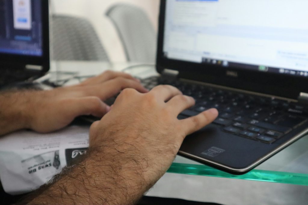 a man is typing on a laptop computer